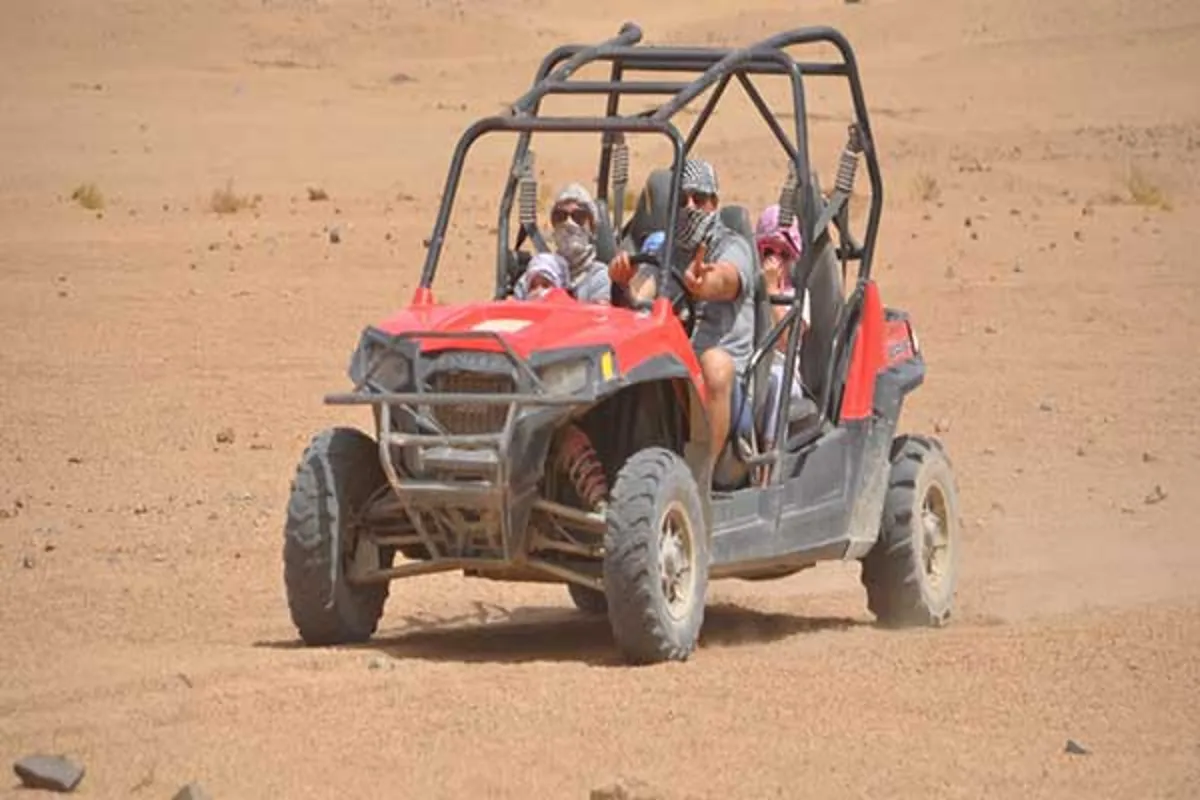 A two-seater buggy on a sandy desert track