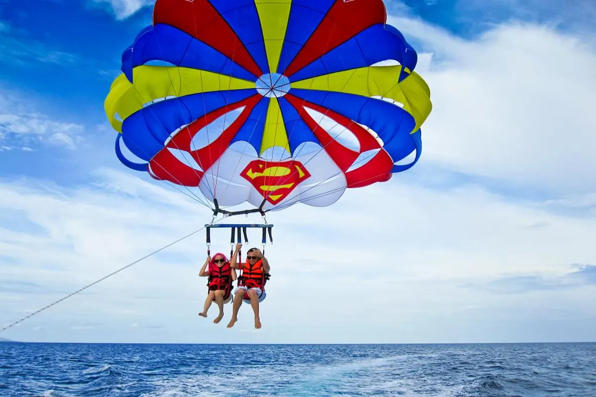A parasail canopy rising above the Red Sea behind a speed boat