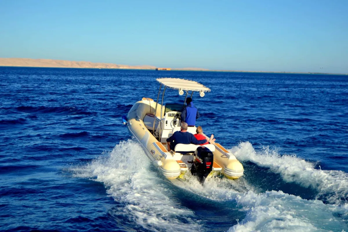 A private speed boat anchored off White Island in turquoise water