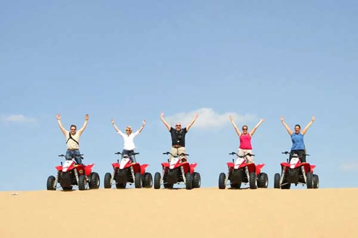 Quad bikes, buggies and a jeep lined up at the desert base camp